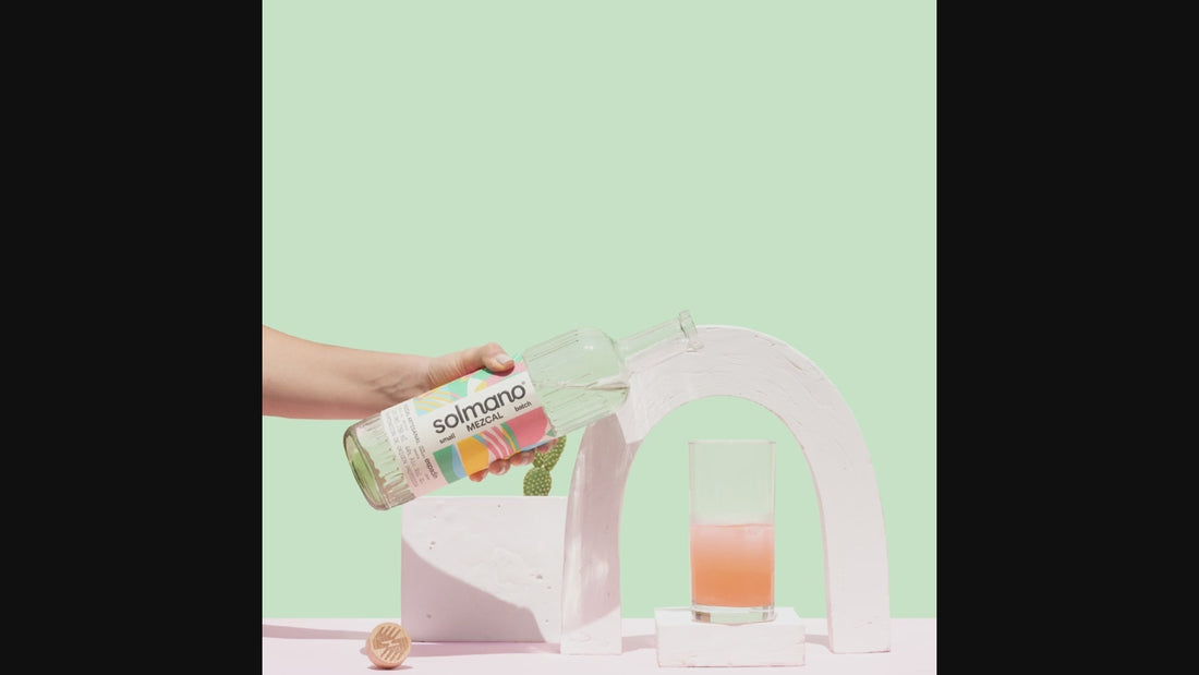 hand pouring liquid from bottle into glass
