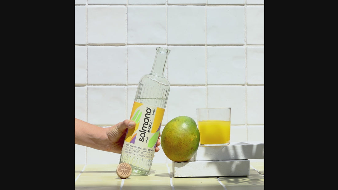 hand pouring liquid from bottle into glass